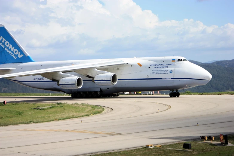 a white and blue passenger jet sitting on top of an airport runway