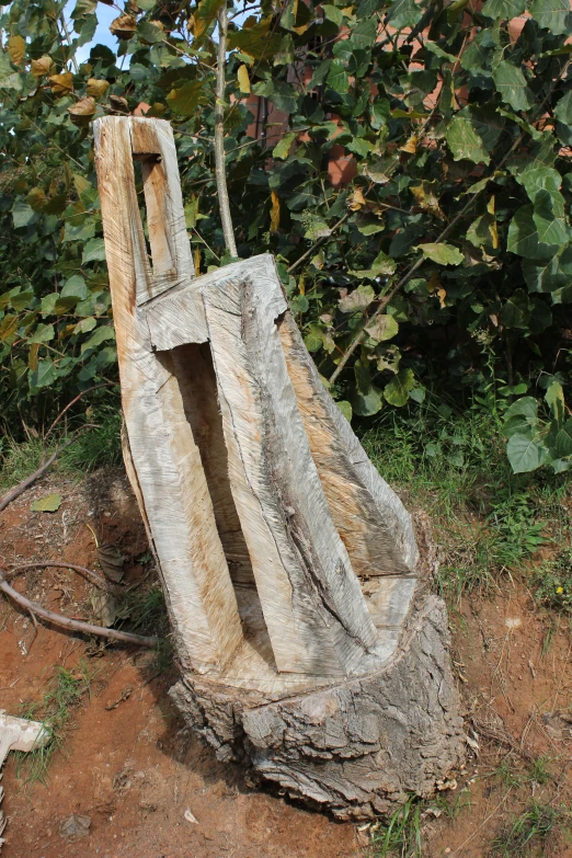 a concrete structure on a dirt field next to trees