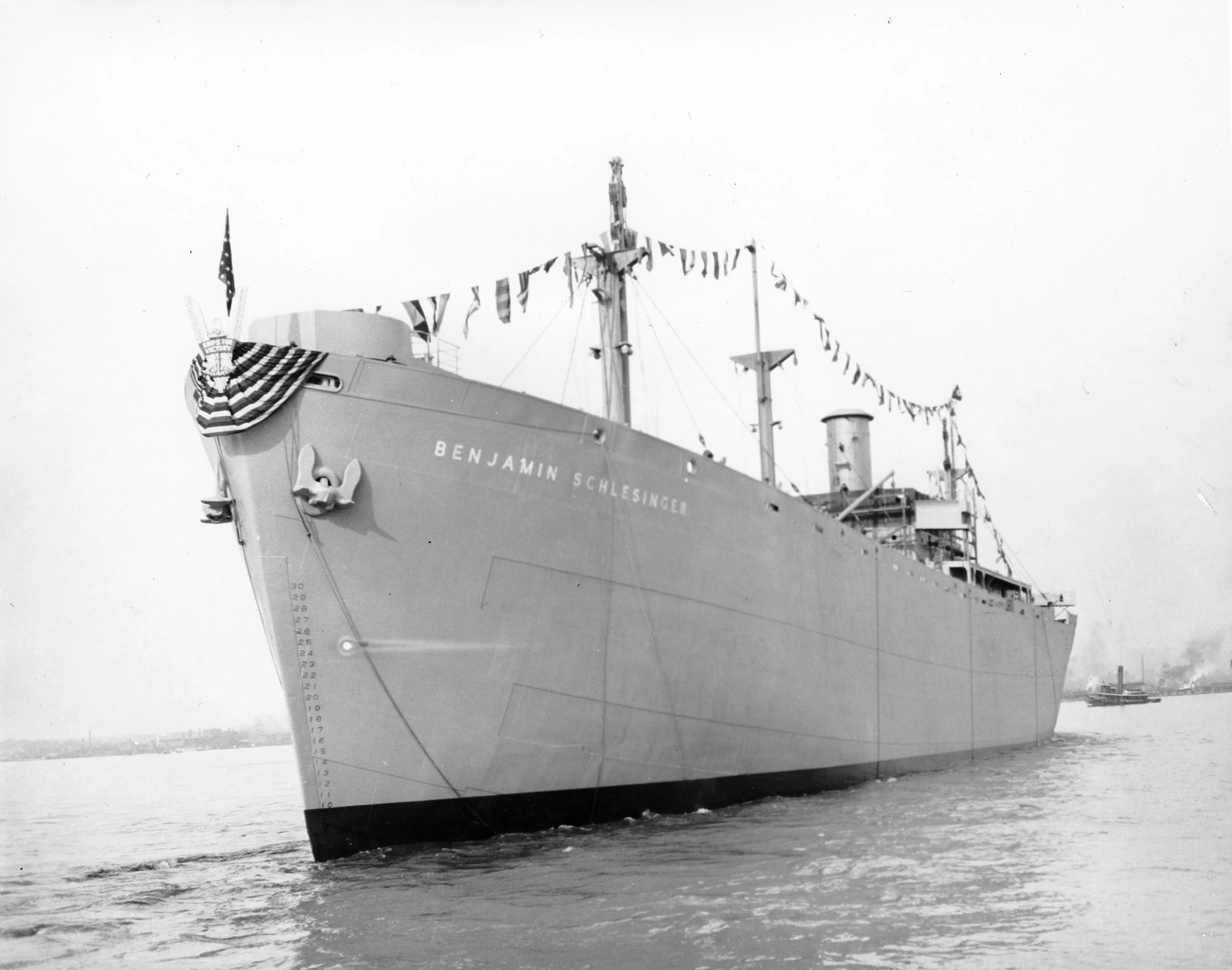 a navy ship with a few flags on the side of it