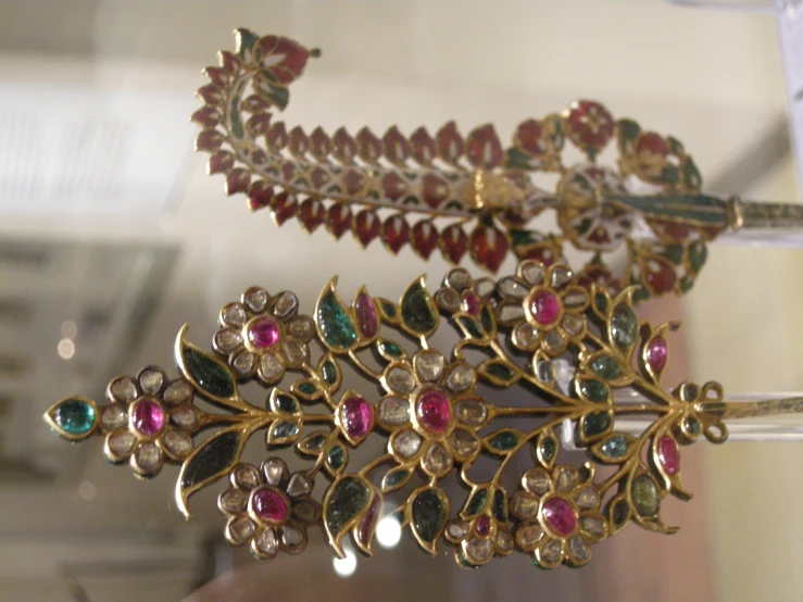 an elaborate piece of gold jewelry in a case