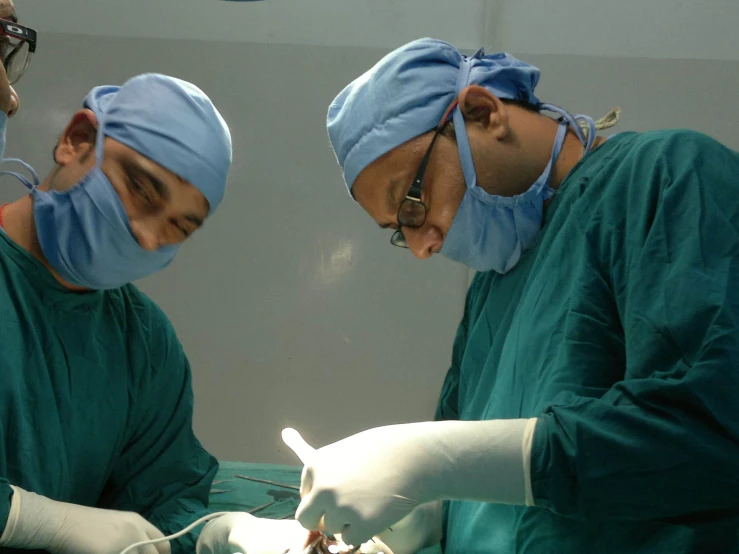 surgeons perform  on a patient in an operating room