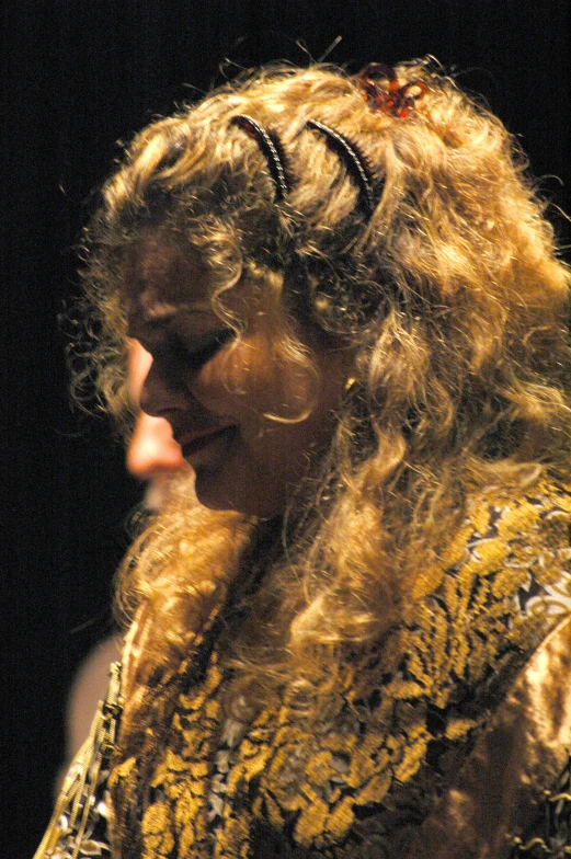 a woman with wavy blonde hair on stage