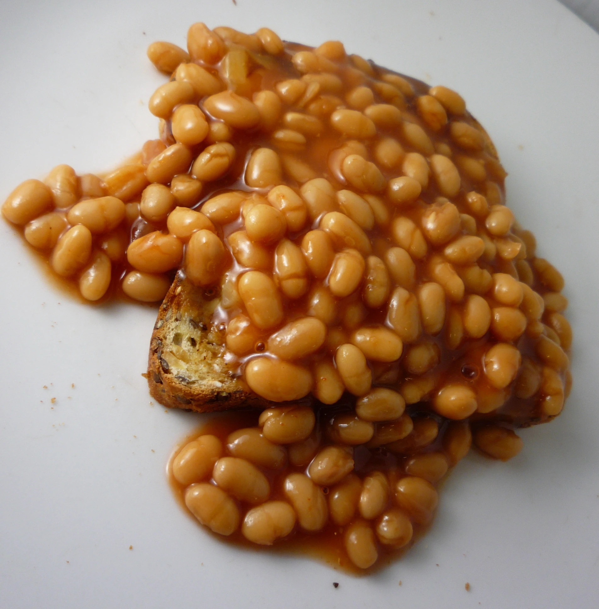 a pile of beans is sitting on a white plate