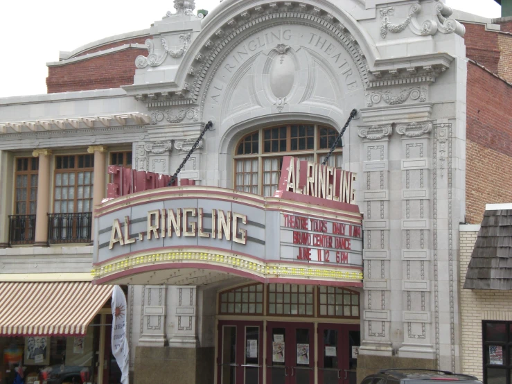 the front of a theater showing an arched window