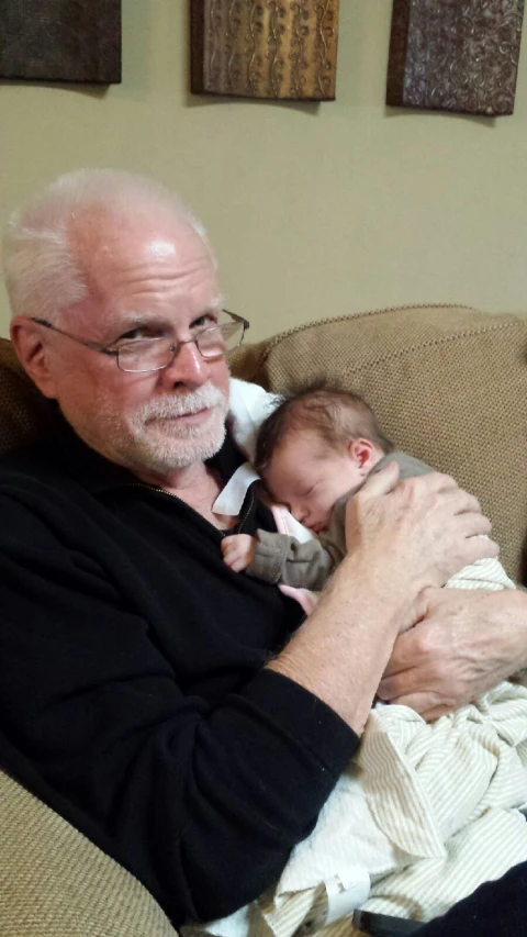 a man in black and white holding a baby