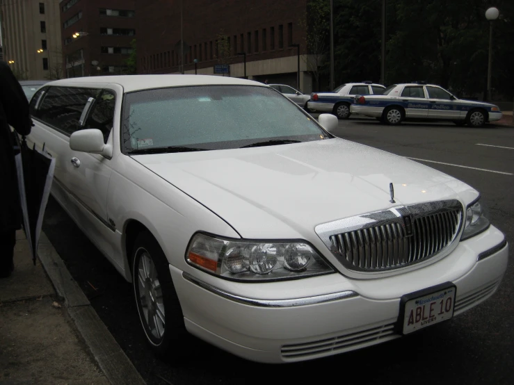 the large white car parked on the side of the road