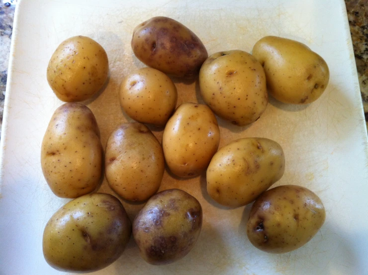 there is potatoes on the  board ready to be cut