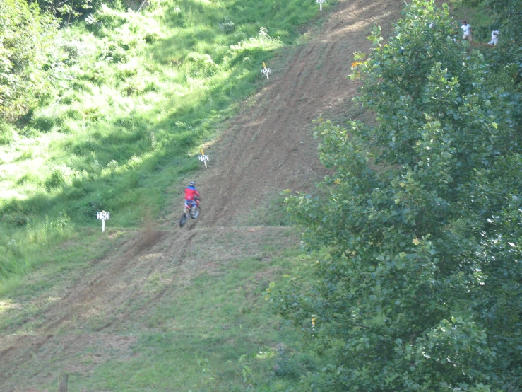 the cyclist is going down a hill in the grass