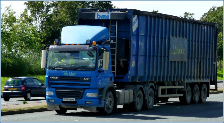 a big blue truck traveling down a road