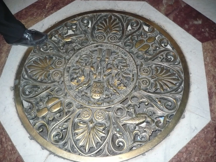 the manhole cover is decorated with gold filigrees
