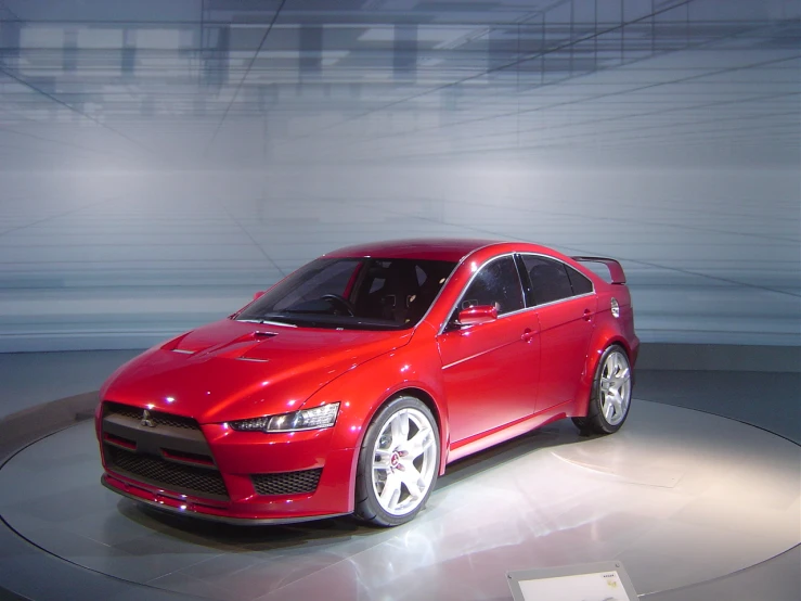 the red car is sitting on display in the showroom