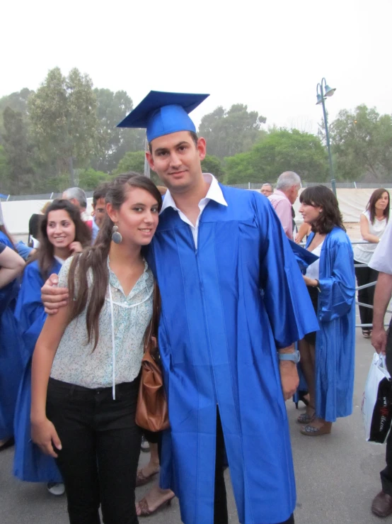 a young male graduate and his wife are posing for a picture