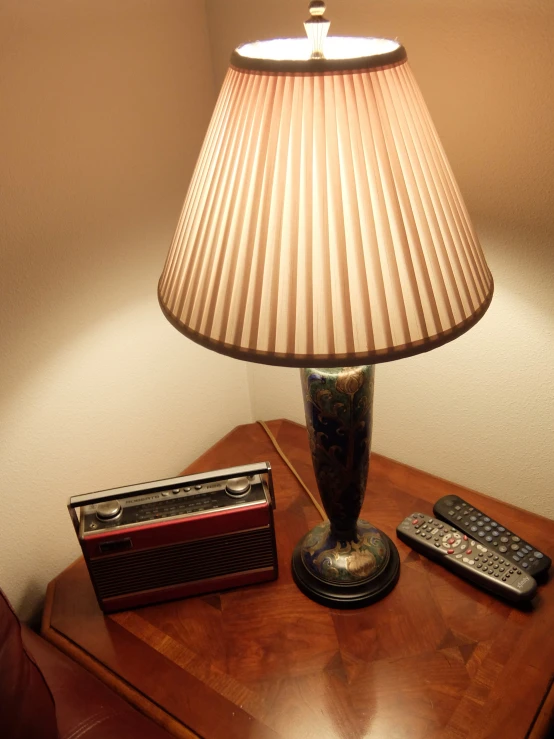 a lamp that has been turned on and is next to two remotes