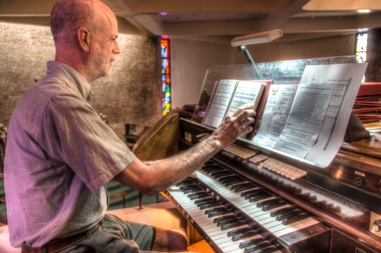 a man sitting in front of an organ playing the piano