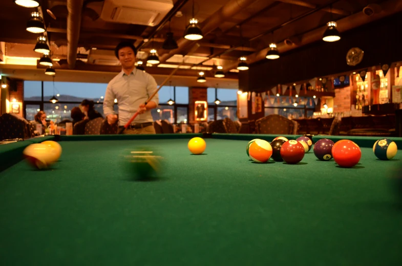 a man and woman standing behind a pool table