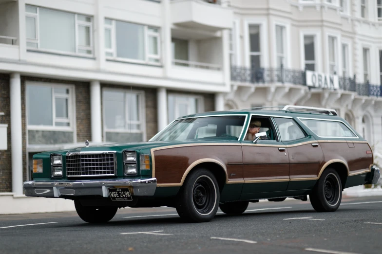 a station wagon car driving down the street