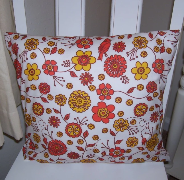 a white pillow with orange and red flowers