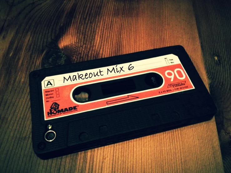 a cassette tape next to the word a madeout mix e on a wood surface