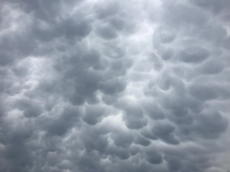 an overcast sky with clouds and the plane flying in it