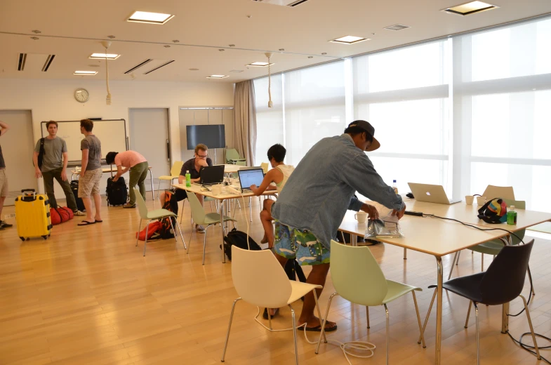 people are in the background while one of them stands over a table