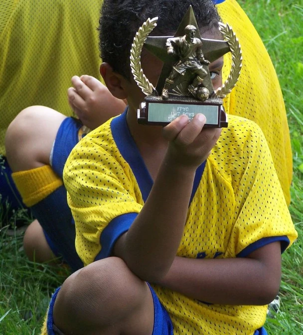 a small child looking through a trophy cup