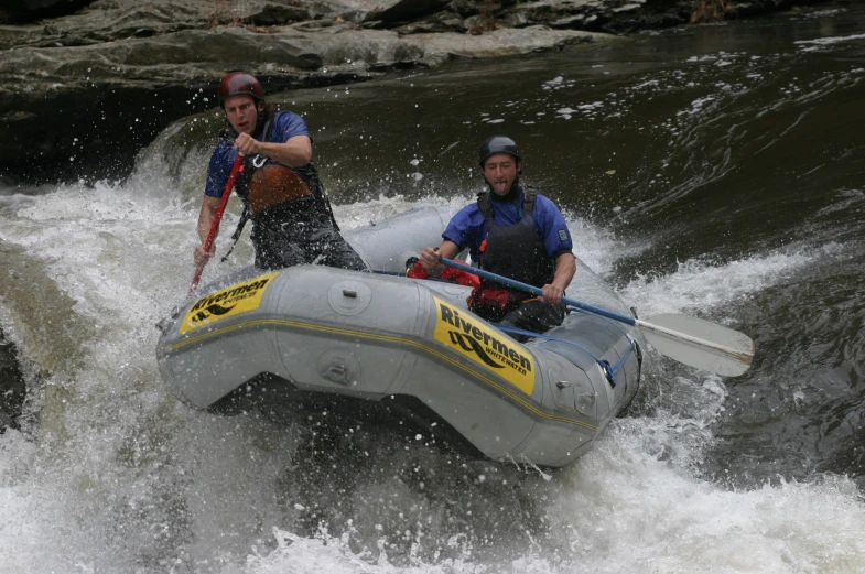 two men are riding in an inflatable raft