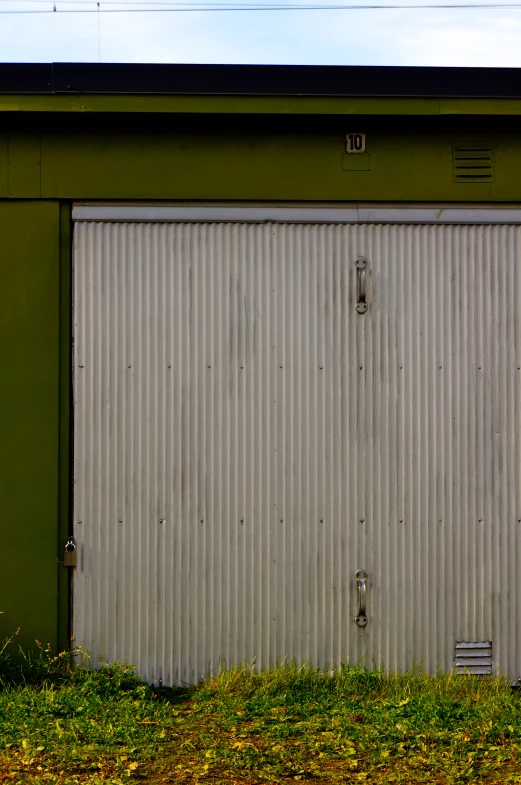 two white doors are open in front of a metal building