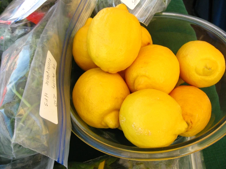 some lemons sit inside a glass bowl