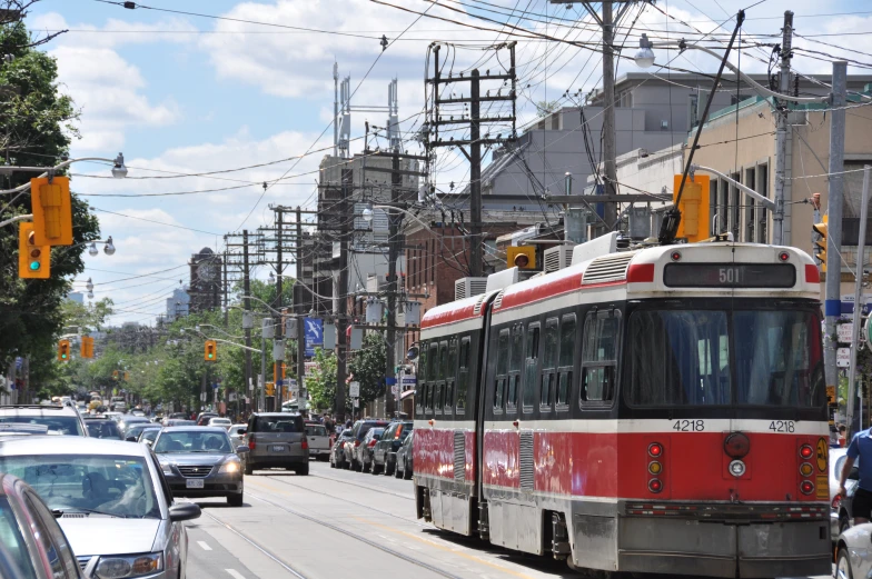 a red and white street car traveling down a road