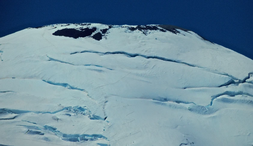 the blue sky is very clear above a white mountain