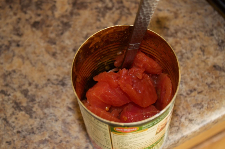 a cup of soup with tomatoes on the table