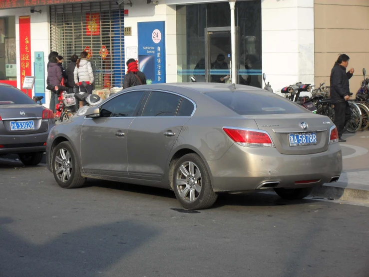 a silver car sitting on the side of the road near motorcycles