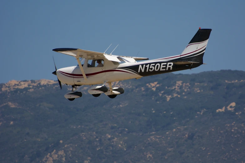 there is a small black and white airplane flying in the air