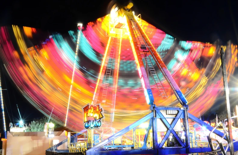 an amut park ride at night with a carnival in the background