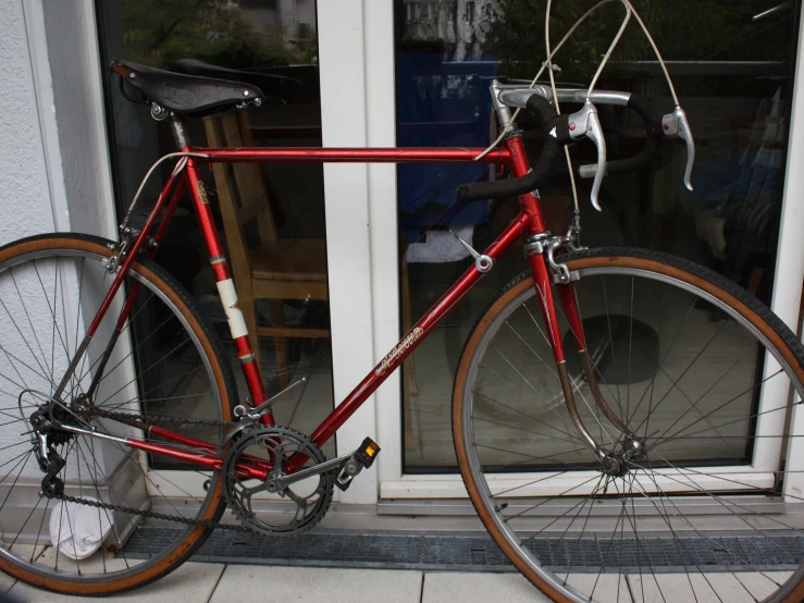 there is a red bicycle parked on the outside of a building