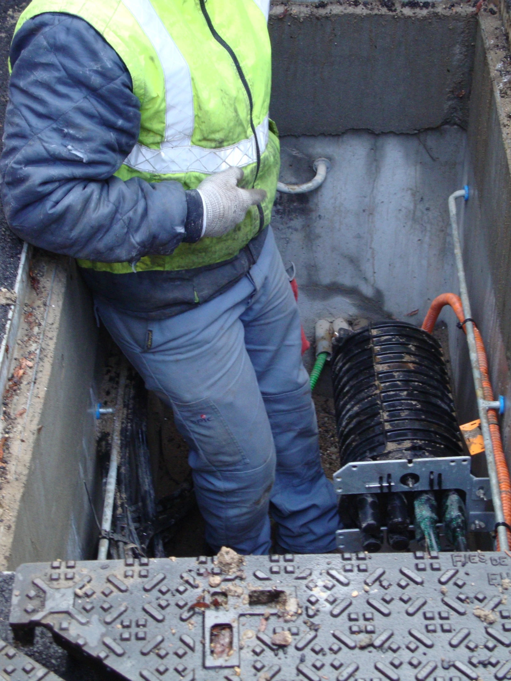 a man kneeling in a hole working on a pump