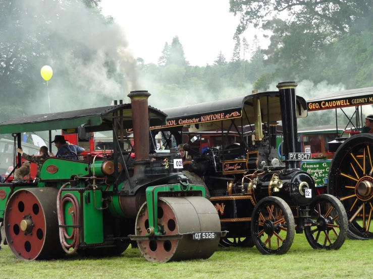 an old fashioned train is parked on the grass