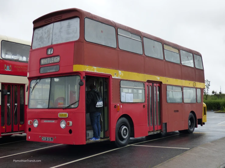 two double - decker buses sit side by side in a parking lot