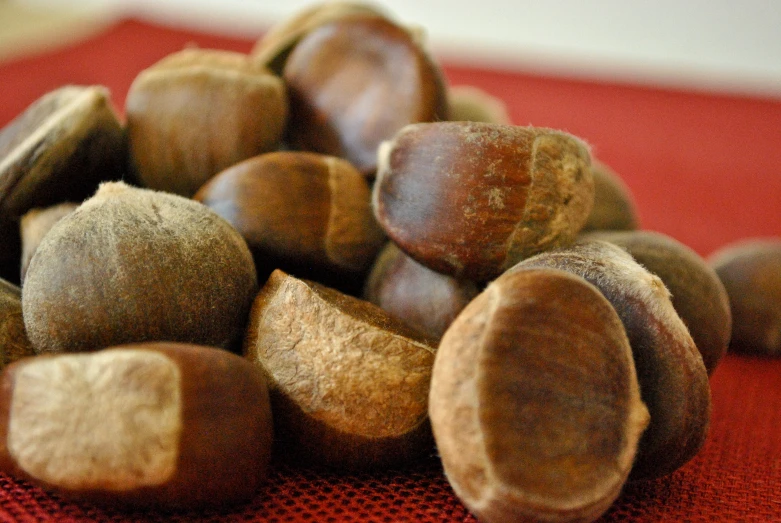 a pile of nuts sitting on top of a red table cloth