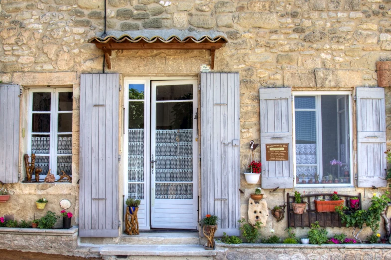 two white wooden doors outside a stone building