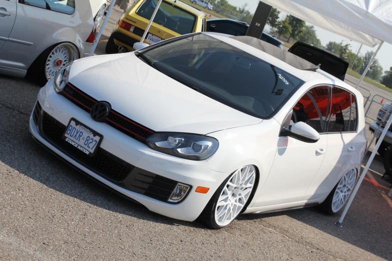 a white vw jetty parked in front of other cars