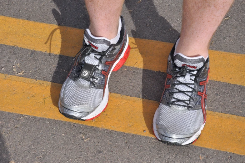 a man's shoes in red and white are seen in this picture