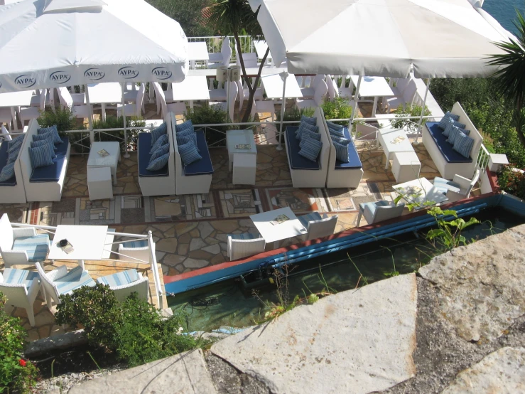 umbrellas and seating outside an outdoor cafe on the banks of a river