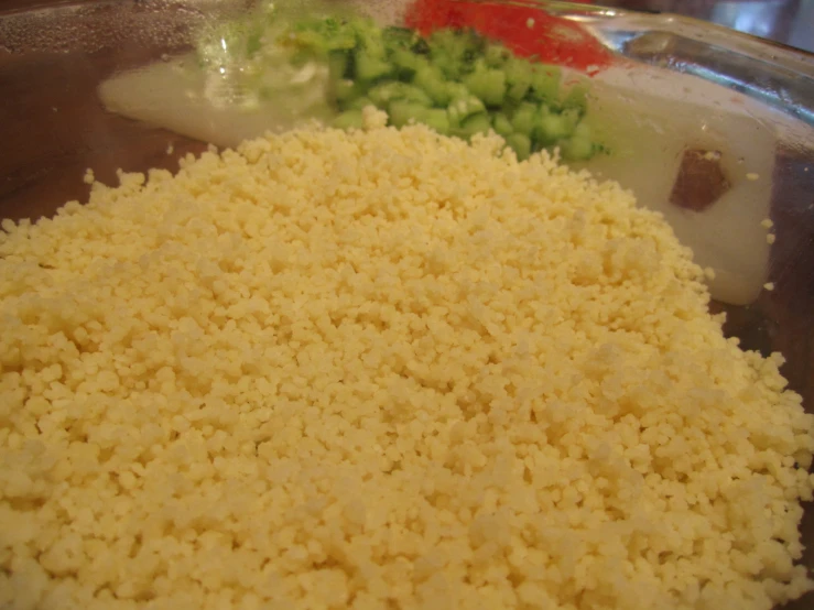 a glass bowl full of various foods that is being cooked