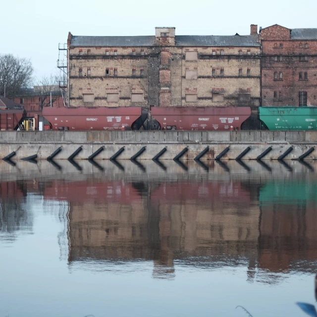 an industrial building along a river with two side walls
