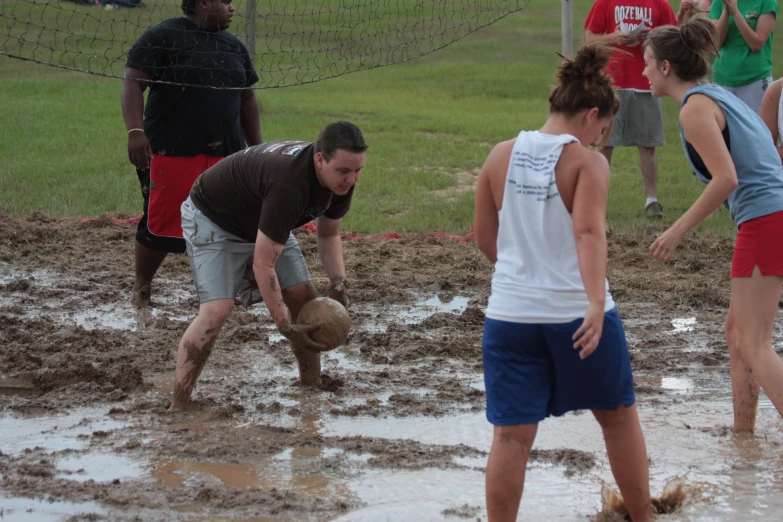 a group of people on a field playing in mud