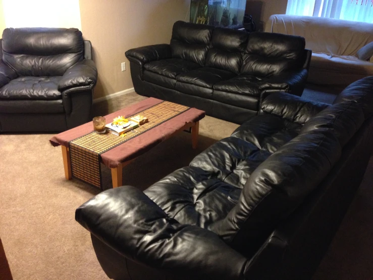 a living room filled with leather furniture and a table