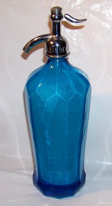 an ornate blue glass bottle with a silver spout