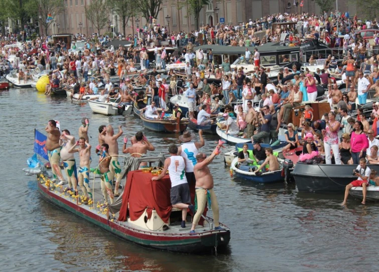 a boat with men waving to the crowd in a lake