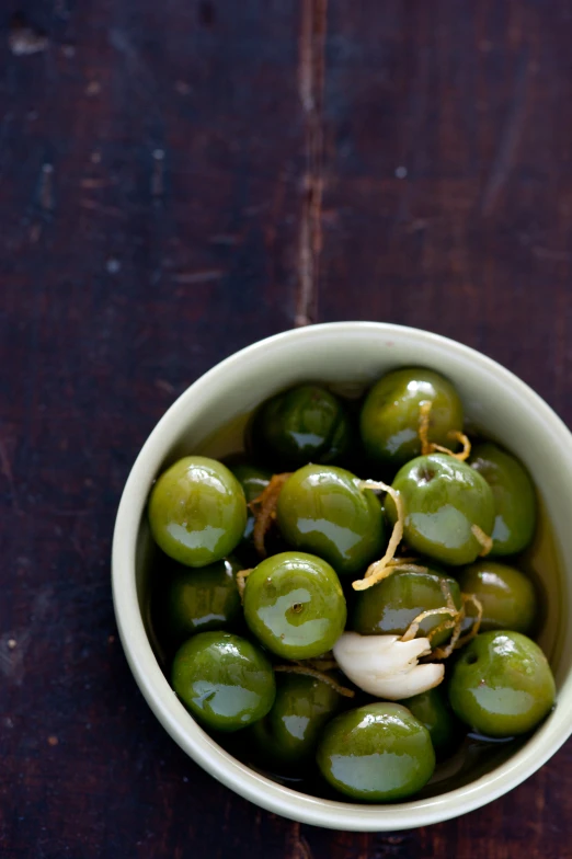 some green olives are placed in a bowl